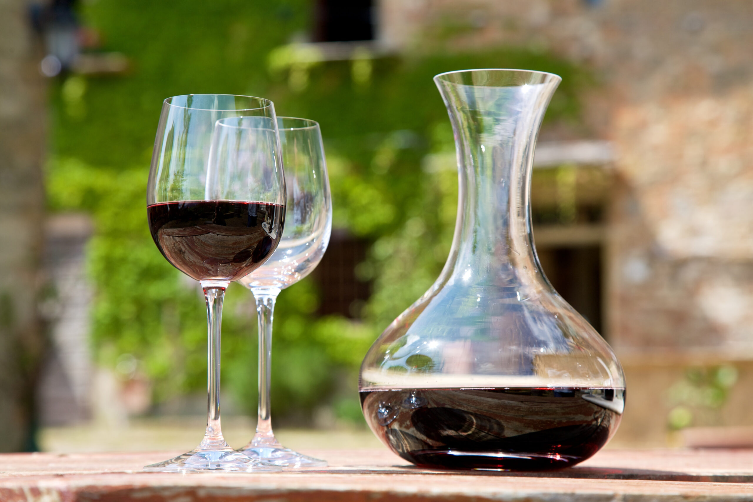 Red wine in a wine carafe and a two wine glasses in old vineyard