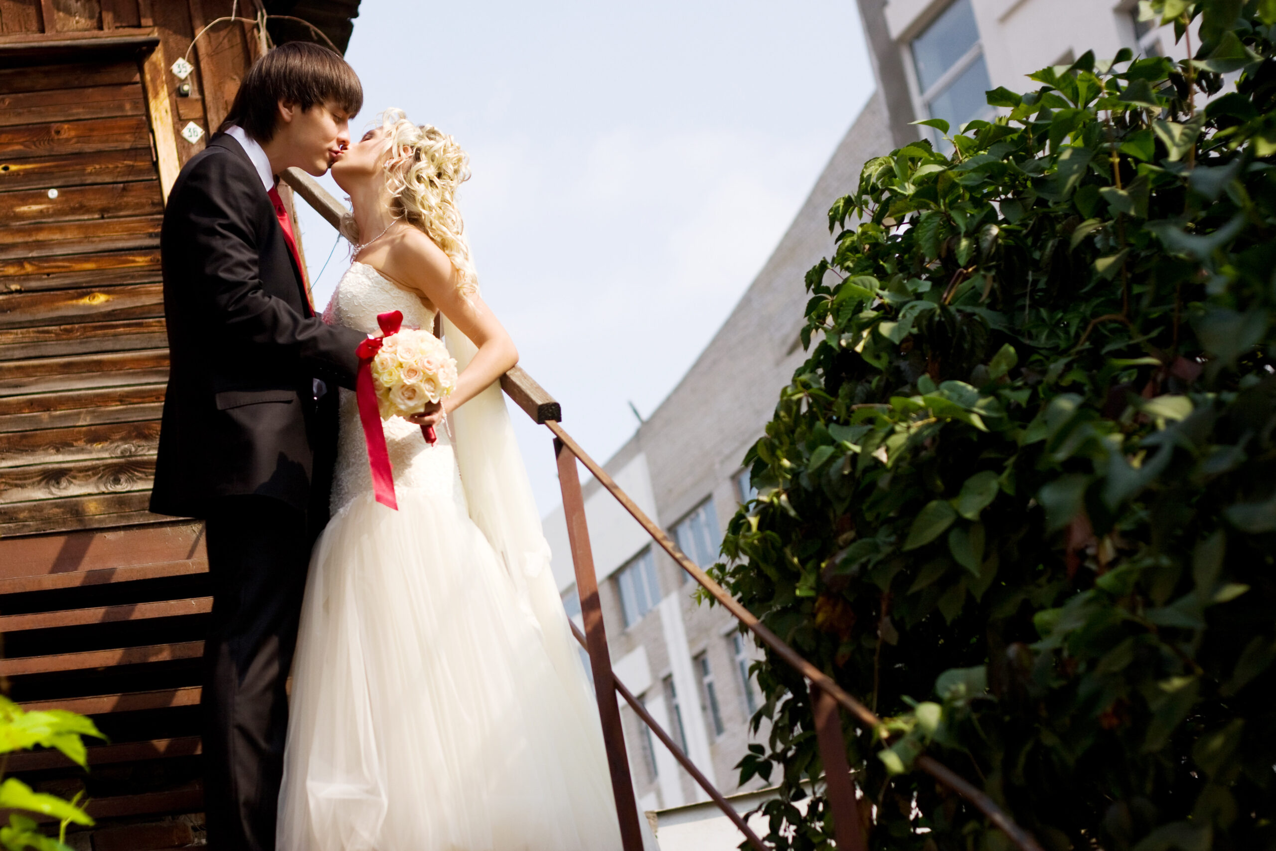 beautiful bride in a white dress with the groom kissing