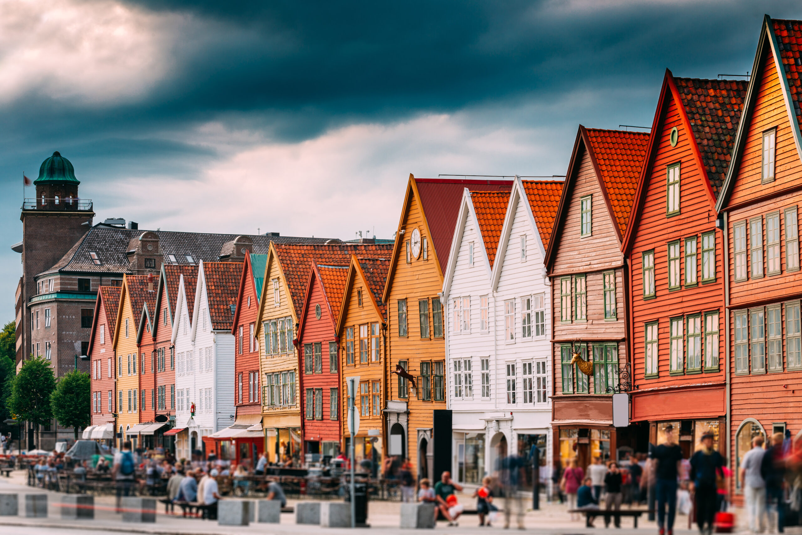 Bergen, Norway. Tourists People Visiting Historical Landmark Houses In Bryggen - Hanseatic Wharf In Bergen, Norway. UNESCO World Heritage Site. Famous Landmark. Destination Scenic