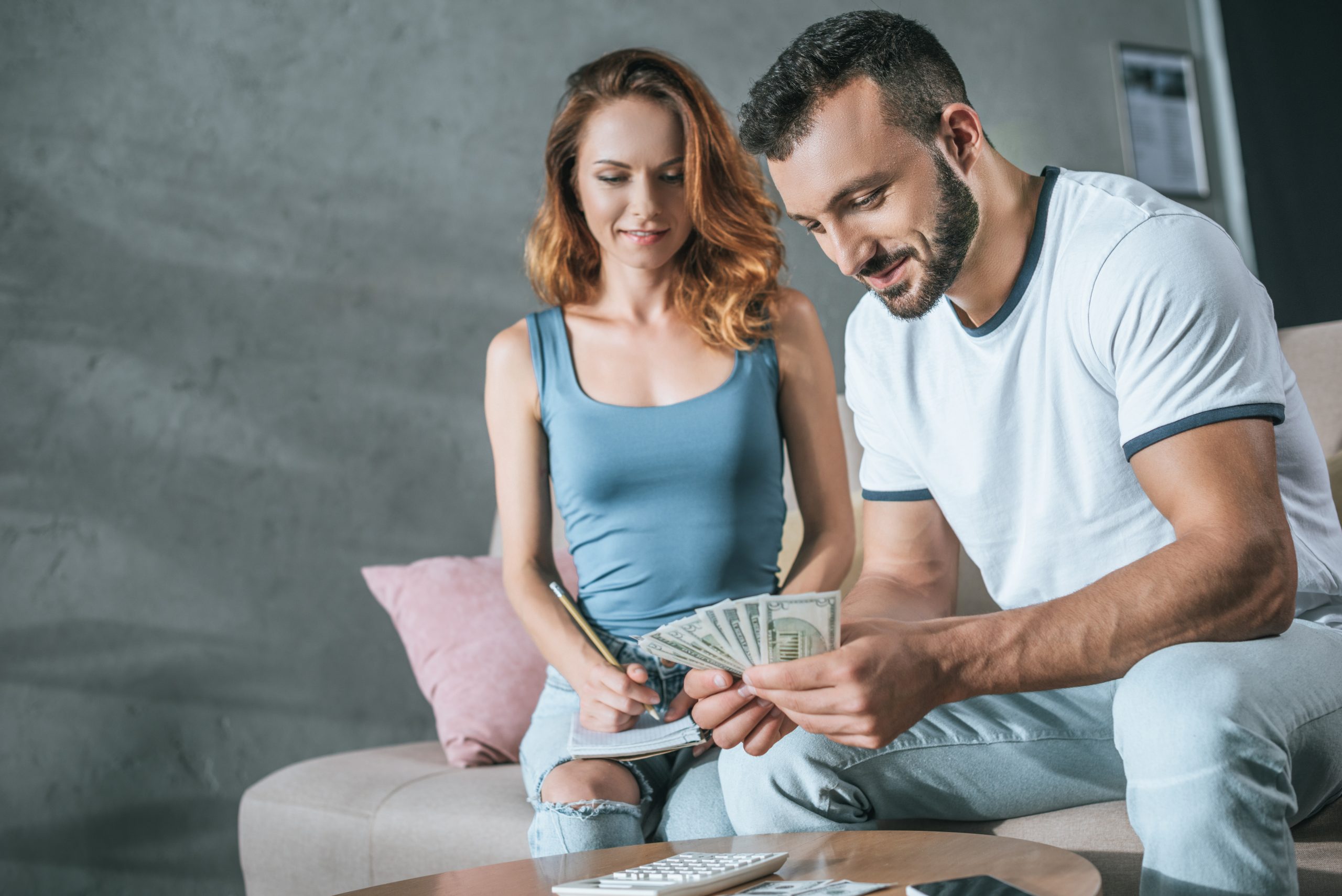 couple planning family budget and counting money in living room