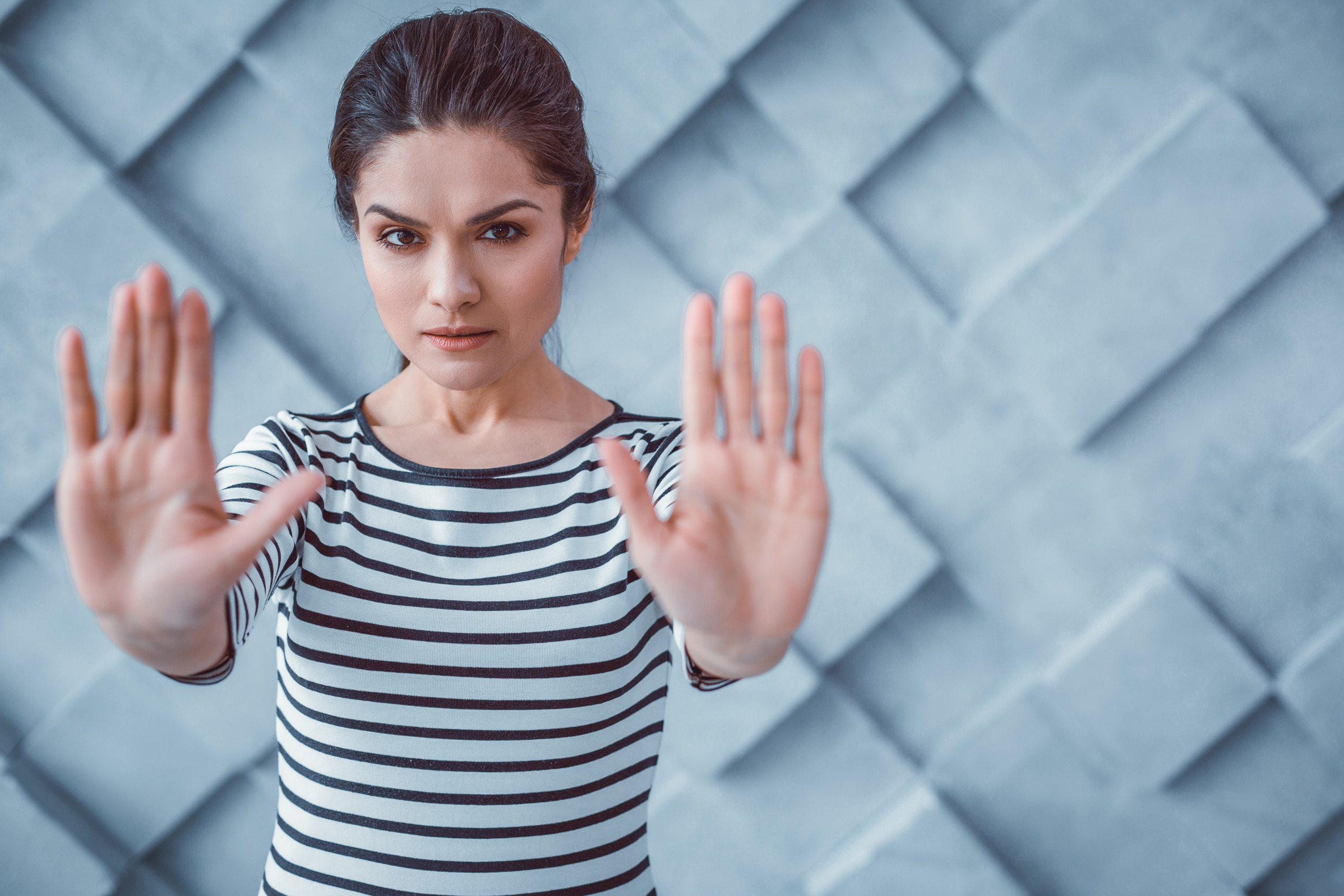 Act of protest. Dissent dark-haired woman pushing her hands forward showing disapprobation of actions and opinions