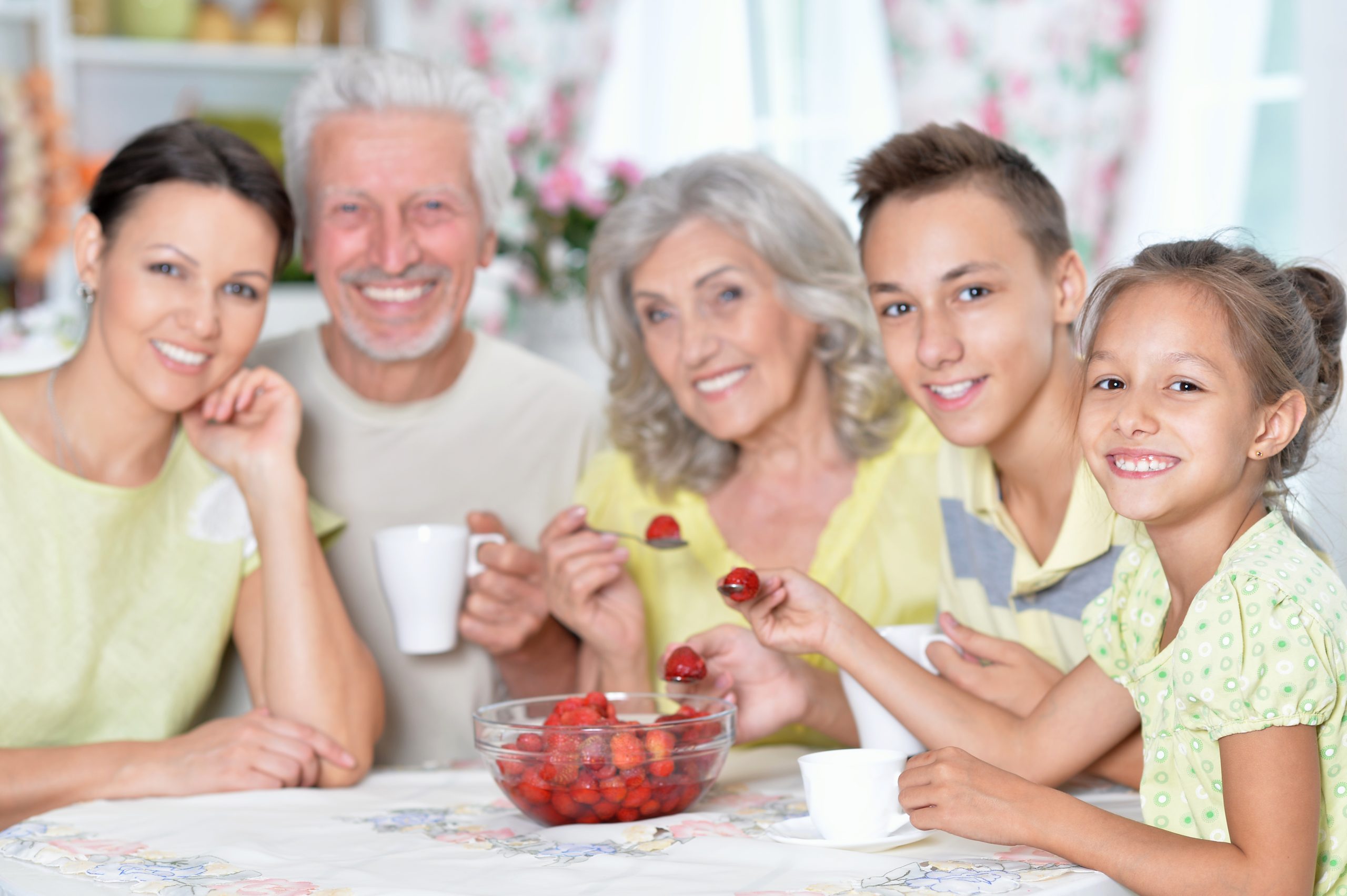 Big happy family eating fresh strawberries at kitchen