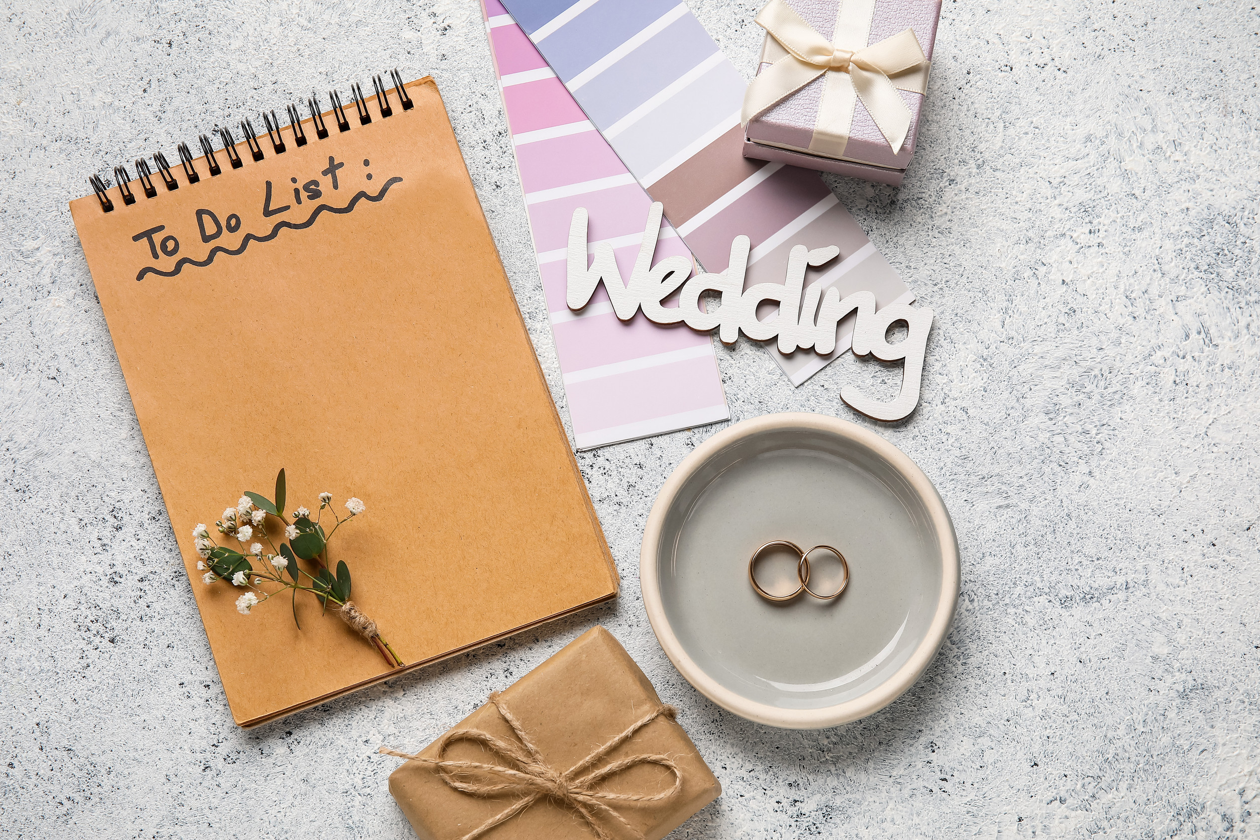 Tray with wedding rings, color samples and notebook with text TO DO LIST on grunge background